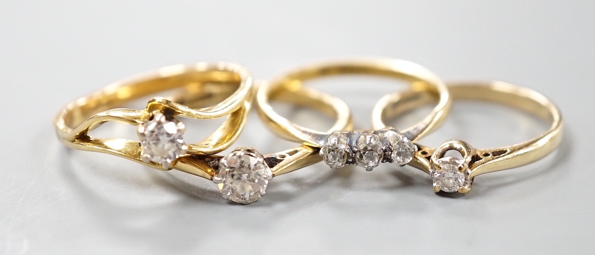 Two 18ct and solitaire diamond rings, an 18ct and three stone diamond ring, gross 7.8 grams and a 9ct and solitaire diamond ring, gross 1.8 grams.